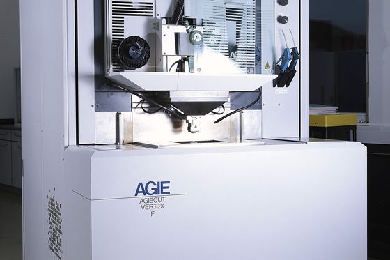 Drahterodiermaschine Agie mit geöffnetem Arbeitsraum und Rundtisch in der Fertigungshalle.