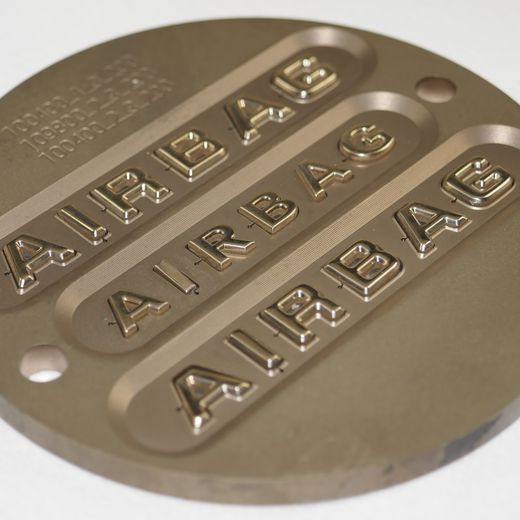 Rundes Beschriftungswerkzeug mit dreifach erhaben gravierter Schrift AIRBAG.
