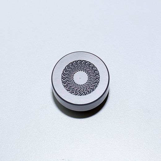 Zylindrischer Formeinsatz mit spiralförmig eingebrachter Feinstruktur auf der Stirnfläche.